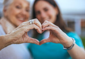 caregiver benefits, women making a heart with their hands